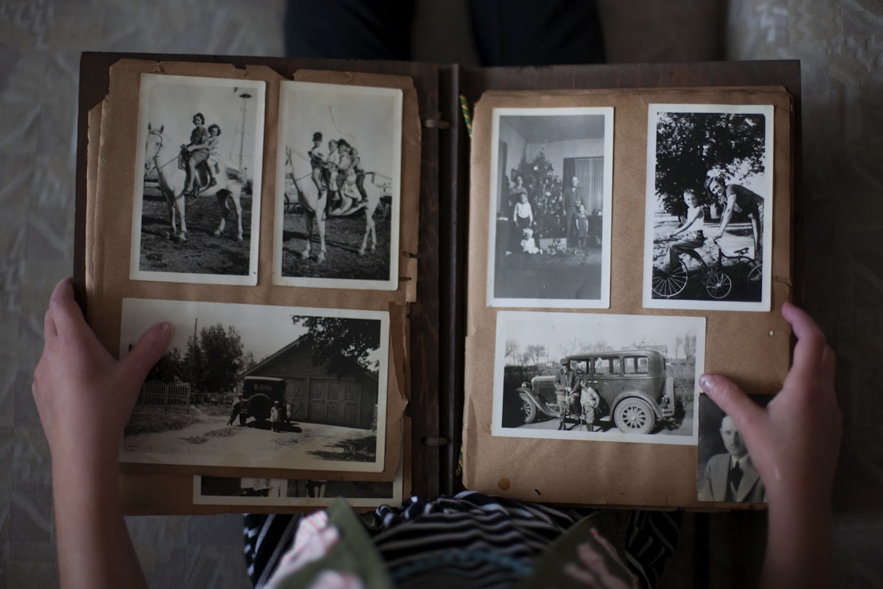 Album s fotografijama različitih veličina otvoren na stolu