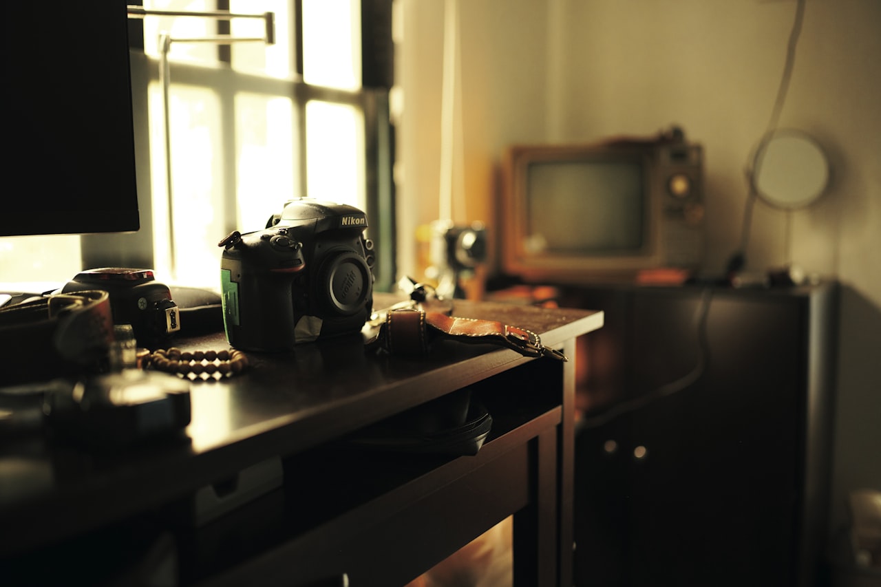 Vintage fotografski aparat i tiskane fotografije na radnom stolu
